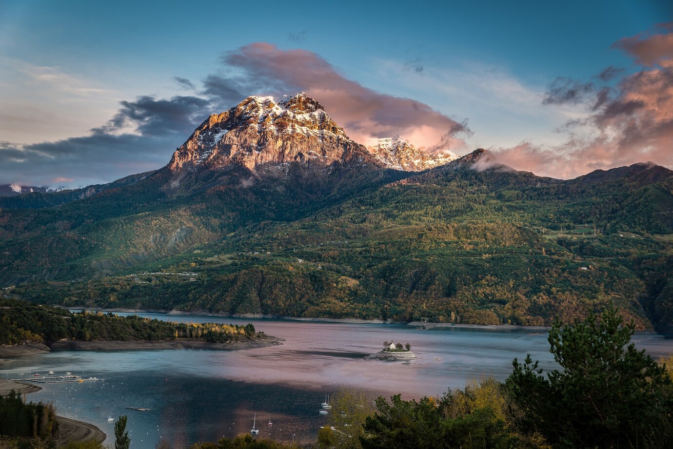 idyllic-shot-huge-mountain-covered-vegetation-with-body-water-its-base_181624-21444